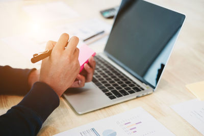 Midsection of woman using laptop on table