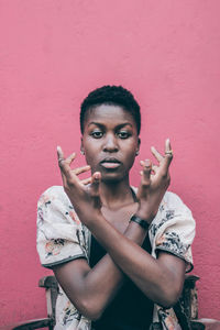 Portrait of young woman with red face against gray background