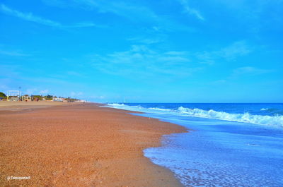 Scenic view of beach against blue sky