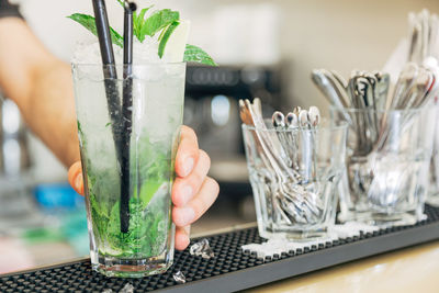 Cropped hand serving drink in restaurant