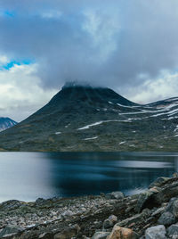 Scenic view of lake by mountains against sky