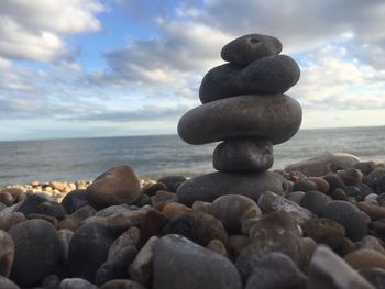 Stack of stones on beach against sky