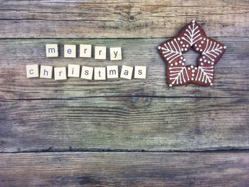 Directly above shot of merry christmas text on toy blocks with cookie at table