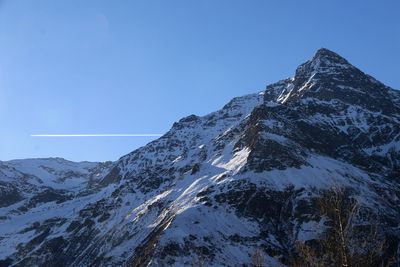 Scenic view of snow covered mountains against clear blue sky