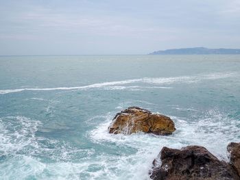 Scenic view of rocks on beach against sky