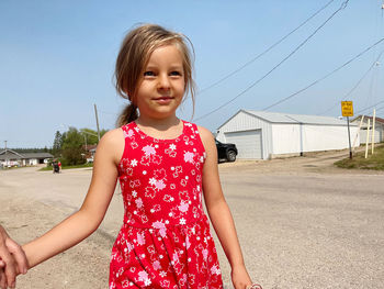 Portrait of smiling girl standing against sky