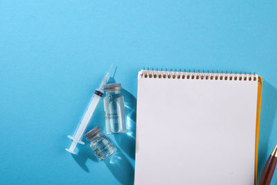 High angle view of pen on table against blue background