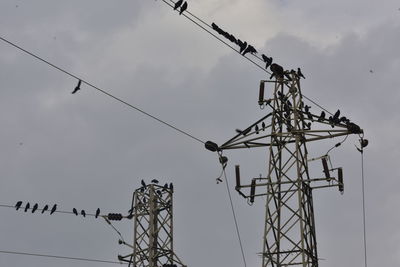 Low angle view of electricity pylon against sky