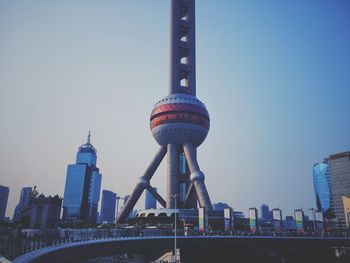 Communications tower in city against clear sky