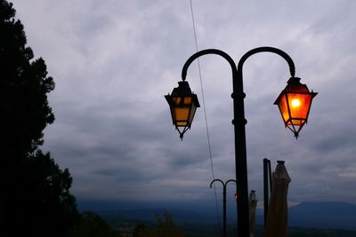 Illuminated street light against sky