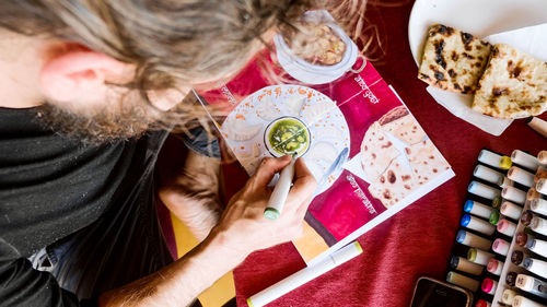 High angle view of man drawing in book