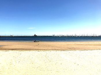 Scenic view of beach against clear blue sky