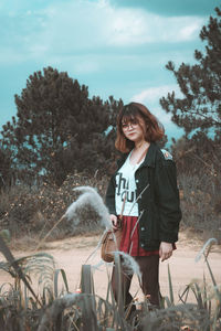 Full length of woman standing on field against sky