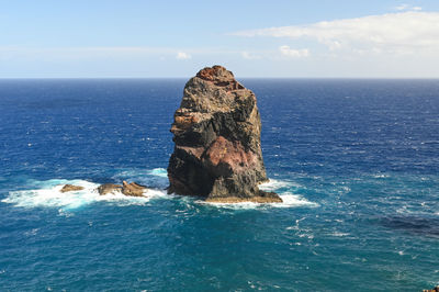 Rock formation in sea against sky