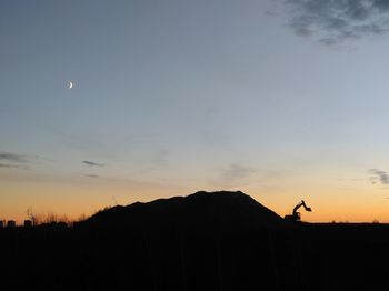 Silhouette landscape against sky at sunset