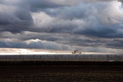 Scenic view of field against cloudy sky