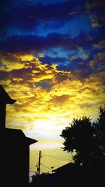 Low angle view of silhouette tree against dramatic sky