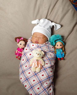 Portrait of cute baby girl lying on bed