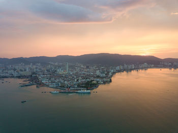 Scenic view of sea and city against sky during sunset