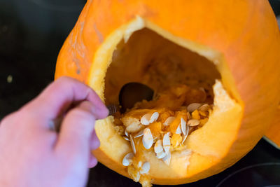 Close-up of hand carving a pumpkin