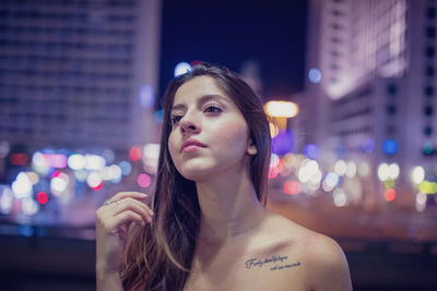 Portrait of woman in city at night