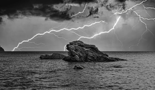 Panoramic shot of rock in sea against sky