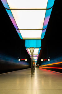 Illuminated railroad station platform at night