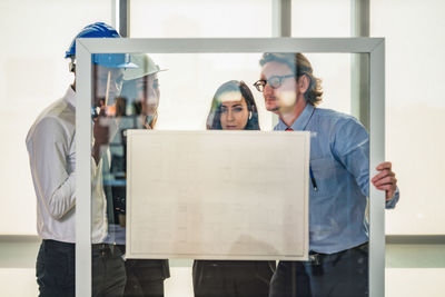 Portrait of a young couple standing against wall