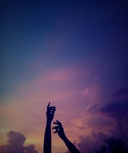 Low angle view of silhouette hand s of person against sky during sunset