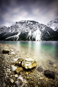 Scenic view of lake and snowcapped mountains against sky