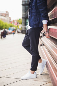 Low section of man standing on footpath