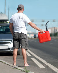 Rear view of man standing on road