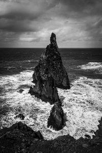 Rock formation on beach against sky