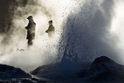 People amidst geyser