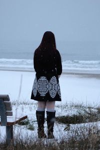 Rear view of woman standing on beach