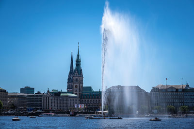 Panoramic view of buildings by river against sky in city