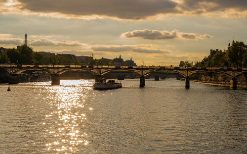 Bridge over river against sky during sunset