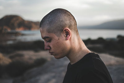 Side view of young man against sea