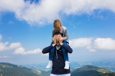 Woman standing on mountain against sky