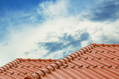 Low angle view of roof of building against cloudy sky