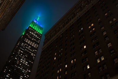 Low angle view of illuminated skyscraper at night