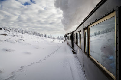 Snow covered train against sky