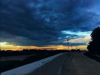 Road passing through landscape against cloudy sky