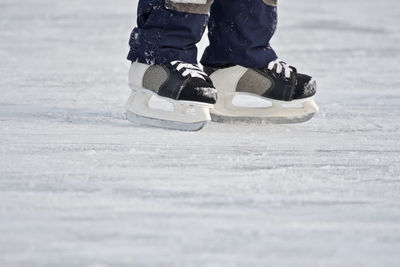 Low section of person ice-skating on rink