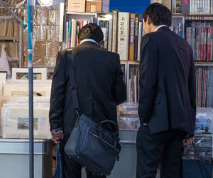 Rear view of men standing in city