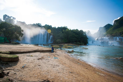 Scenic view of waterfall against sky