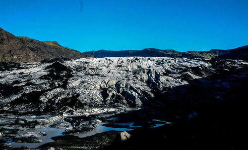 Scenic view of mountains against clear blue sky