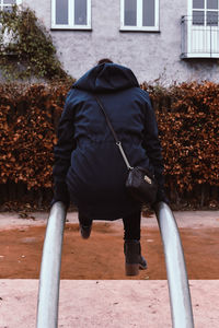 Rear view of man standing by building in city