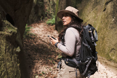 Young woman with gps looking back in a canyon.