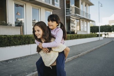 Sisters having fun and giving each other piggyback ride